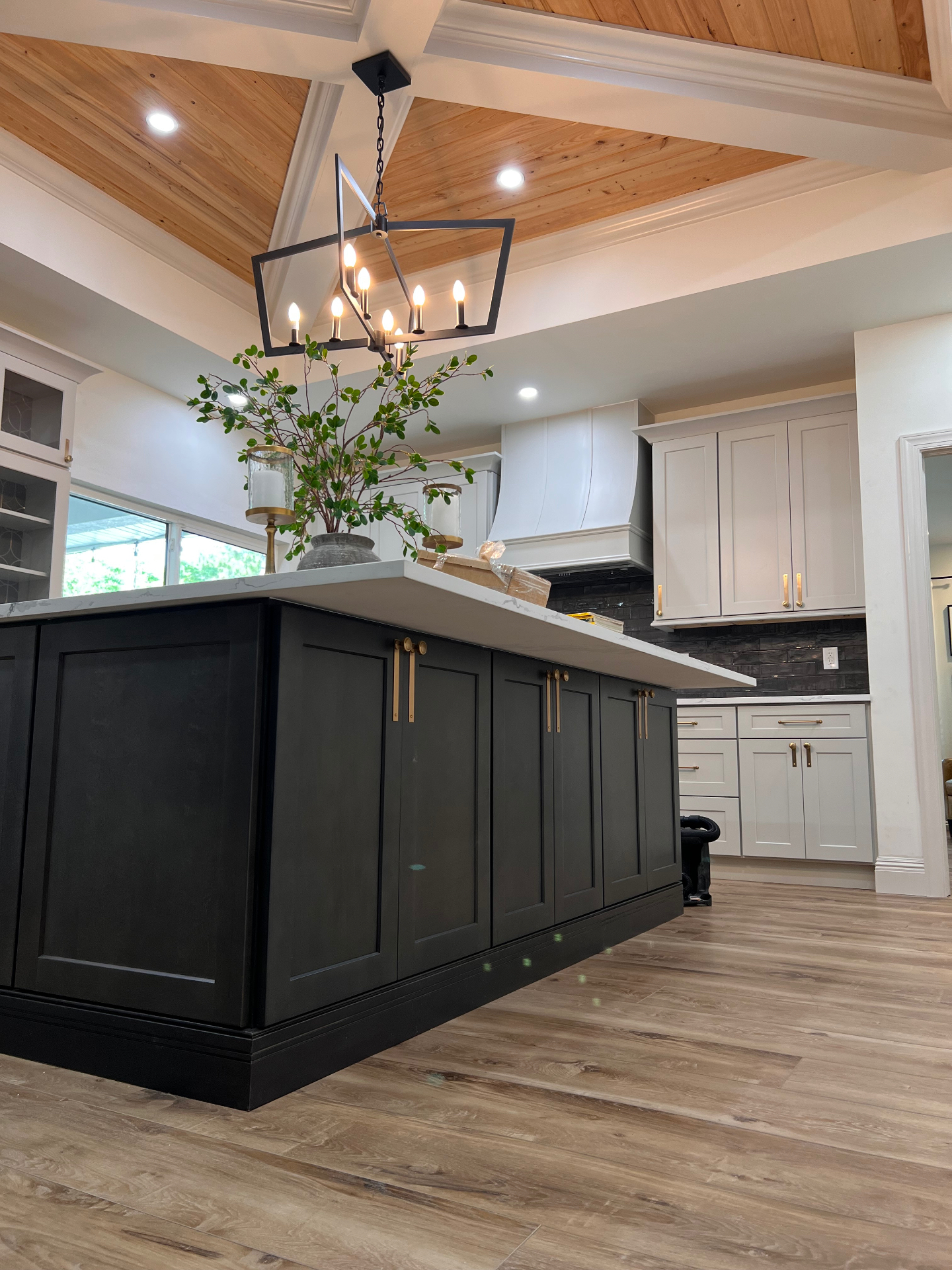 Custom black kitchen island under cypress tongue-and-groove vaulted ceiling on a Taylor Crafted Homes renovation